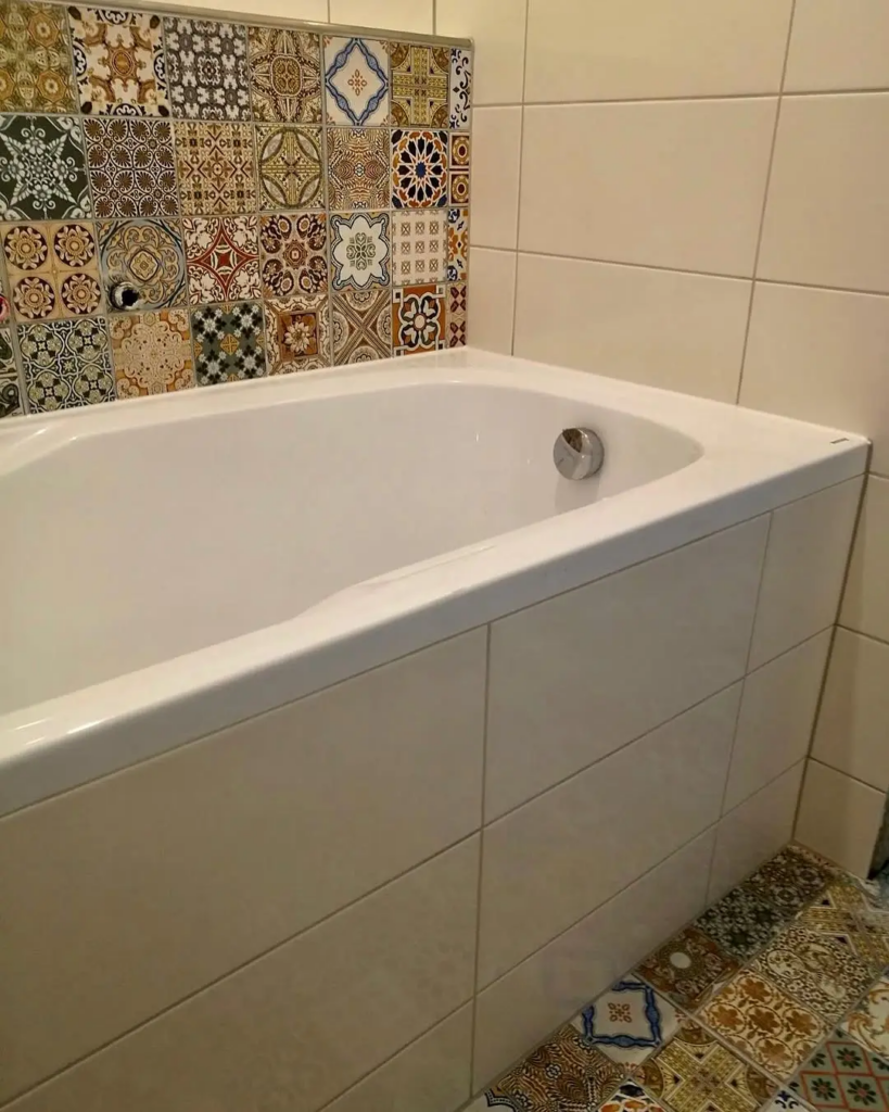 Realizácia kúpeľne s bielou vaňou a dekoratívnym obkladom s patchwork vzorom